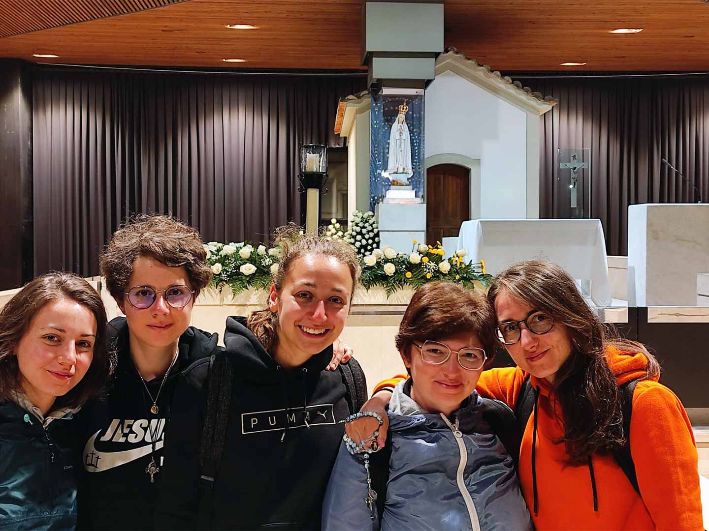 Foto di gruppo Sorelline in Chiesa con alle spalle altare e statua della Madonna e Crocifisso